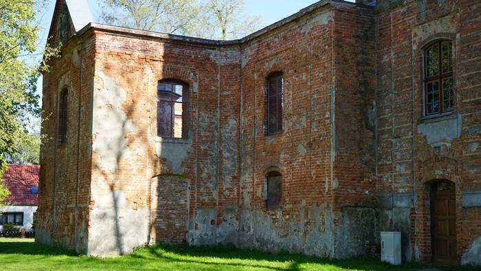 Backsteinmauer eines alten Gebäudes mit mehreren Fenstern