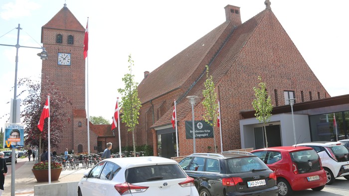 Bygning med klokketårn og biler foran