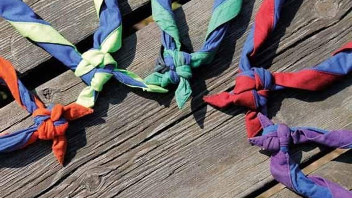 Bunte Tücher liegen auf einem Holzboden