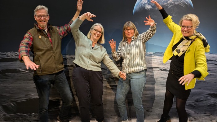 Vier Personen feiern auf dem Mond vor Erdballon