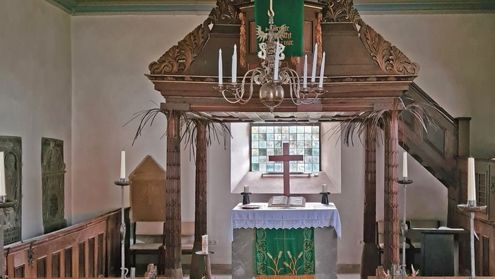 Historisches Kircheninneres mit prunkvollem Altar, hölzernen Kirchenbänken und traditionellen religiösen Verzierungen.