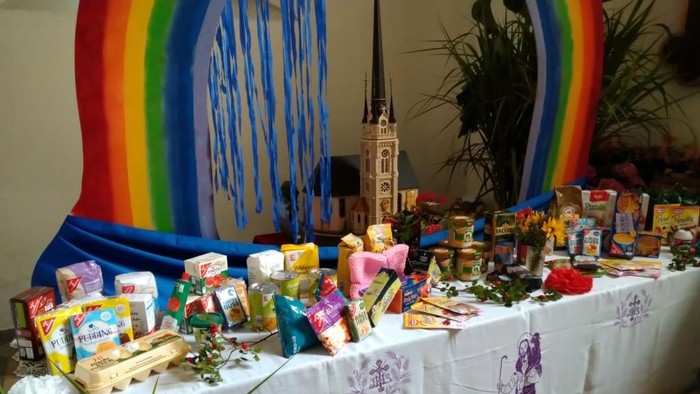 Bunter Tisch mit vielen Geschenken und einer Regenbogen-Dekoration