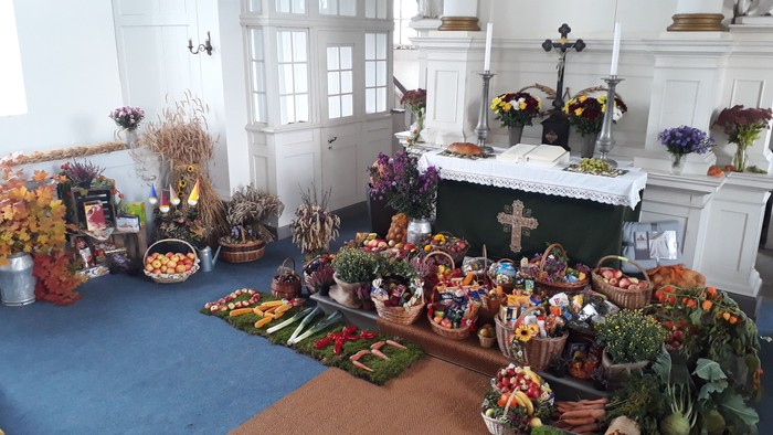 Bunte Blumen und Gemüsearrangements in Kirche