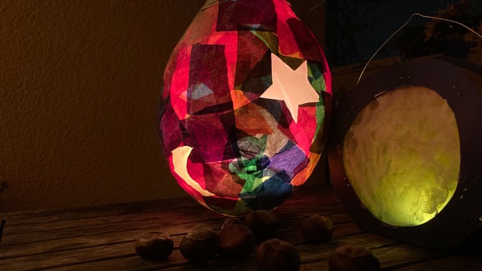 Bunte Glasfenster-Eierlaterne mit Mond und Stern, daneben gelbes Licht