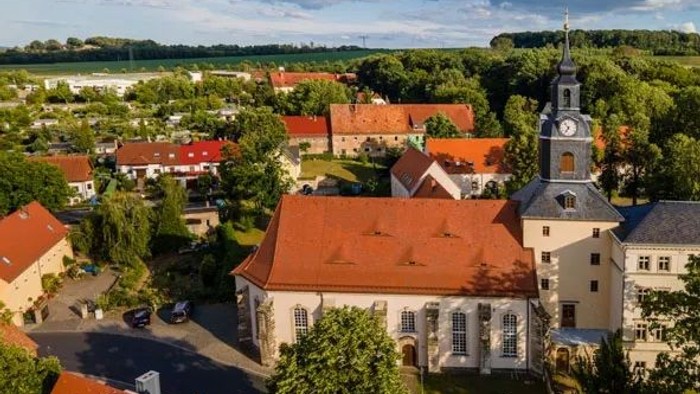 Ein Luftbild einer kleinen Stadt mit Kirche und roten Dächern.