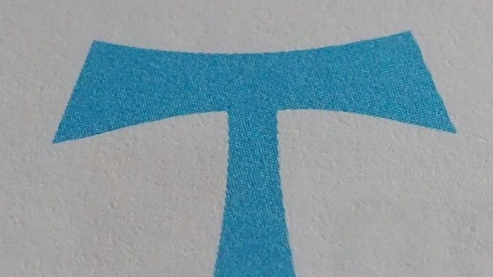 Ein blaues T-förmiges Symbol auf weißem Hintergrund