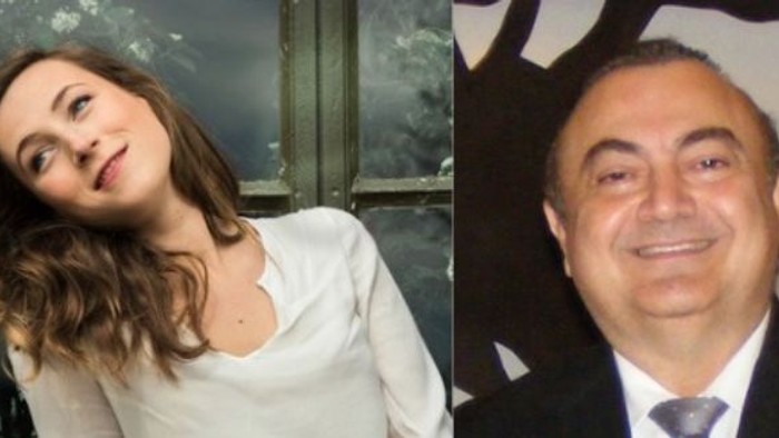 Deux personnes souriantes, une femme aux cheveux ondulés vêtue d'un haut clair et un homme en tenue formelle.
