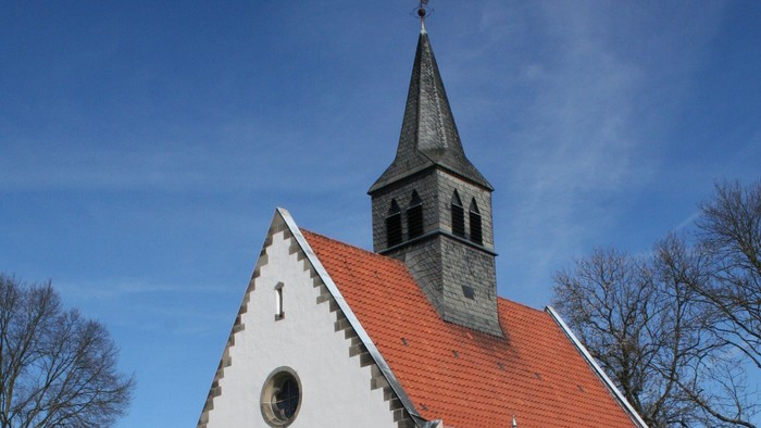 Außenansicht der evangelischen Kirche in Mönchehof. Weiß verputztes Kirchenschiff mit rotem Ziegeldach.