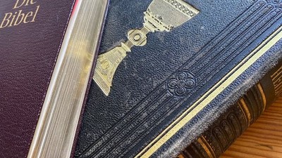 Zwei aufgeschlagene Bibeln auf einem Holztisch