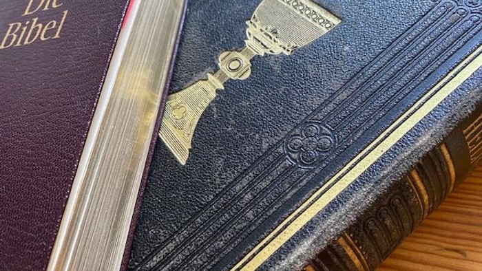 Zwei aufgeschlagene Bibeln auf einem Holztisch