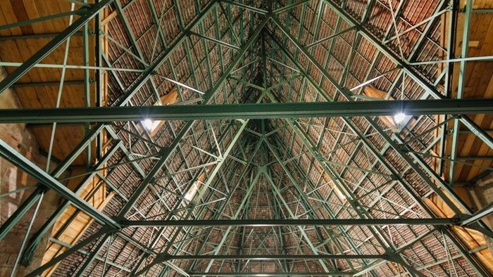 Großer Industriehalleninnerraum mit Metallträgern und Beleuchtung