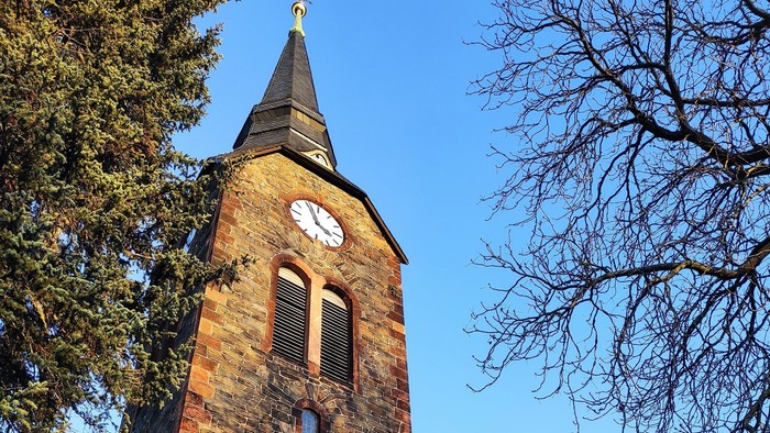 Gotische Kirche mit hohem Turm und Uhr.