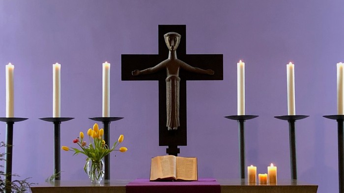 Altar der Weihnachtskirche mit Bibel, Blumen und drei Kerzen geschmückt