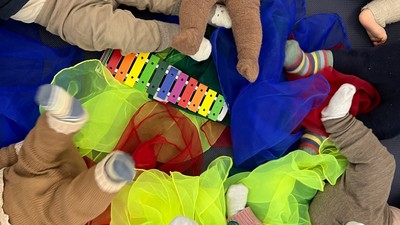 Børn spiller med legetøj på gulv.