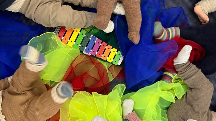 Børn spiller med legetøj på gulv.