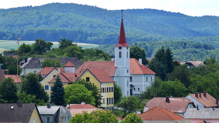 Ein Dorf mit Kirche und umgebenden Hügeln