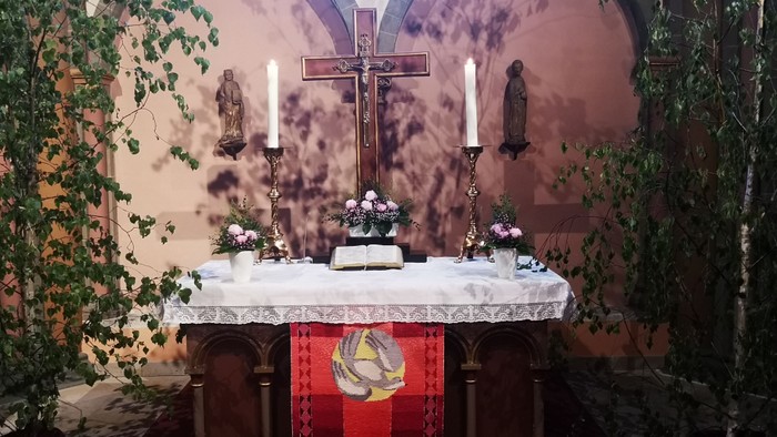 Das Bild zeigt den Altar in der Margaretenkirche mit roten Antependium. Pfingsten.