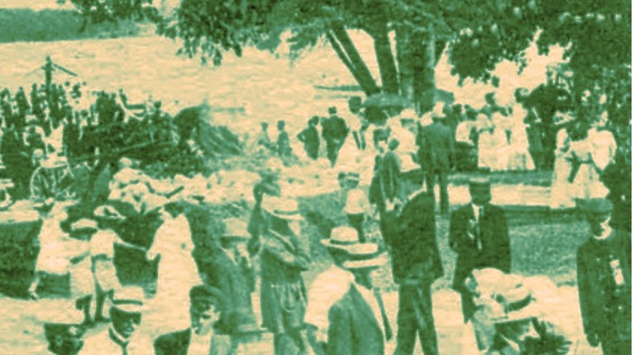 En gruppe af mennesker står ved et træ ved en strand