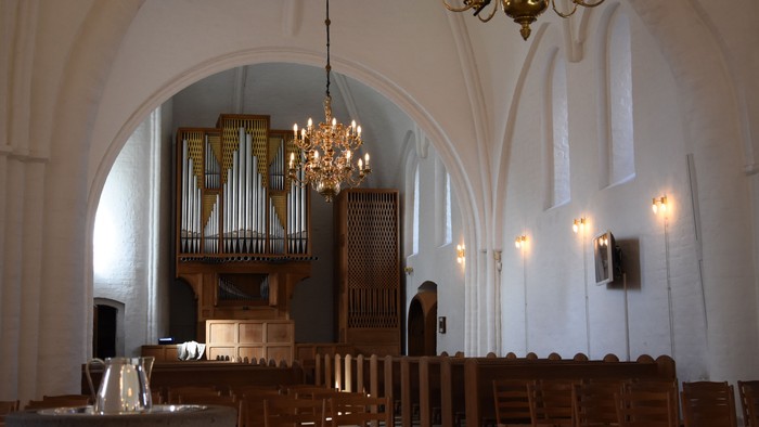Indendørs billede af kirke med orgel og kældere.