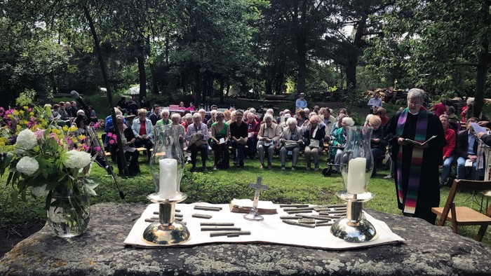 Altar als Stein mit Menschen im Hindergrund