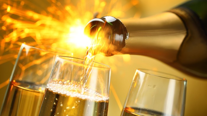 En person serverer vin i glas med gnistreffekt.