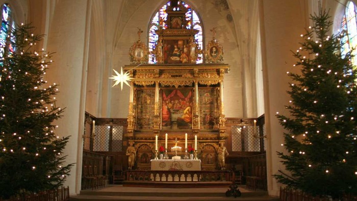 Bild des Altars von Christbäumen eingerahmt