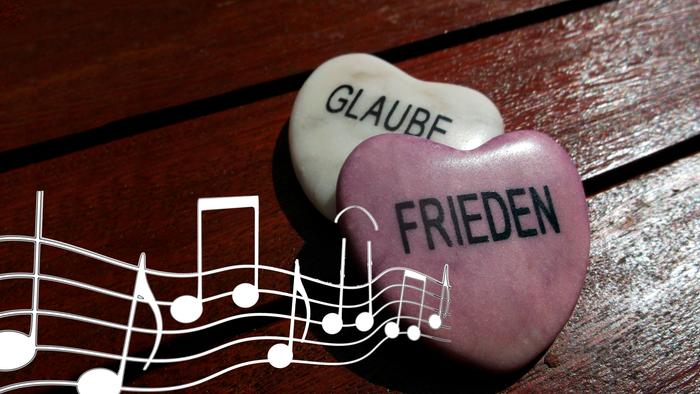 zwei Herzen, beschriftet mit Glaube und Liebe, dazu Musiknoten