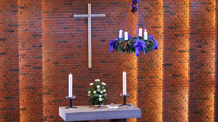 Alter i kirke med lysestake og blomsterarrangement