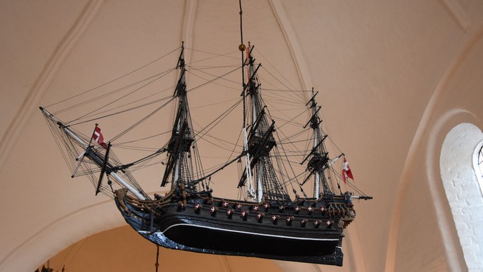 Et modelleskib hænger fra taket i en kirke.