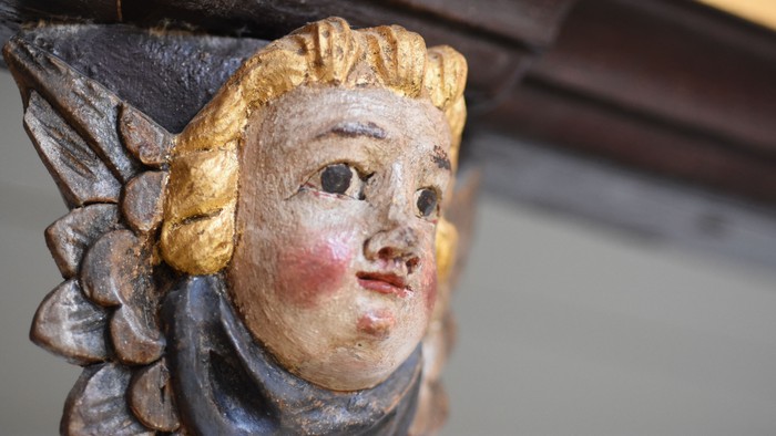 En smuk udskåret figur af en kvinde med gyldne hår og blå øjne.