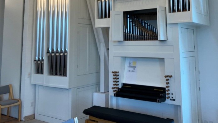 En stor orgel i et lys og rummeligt kirkerum