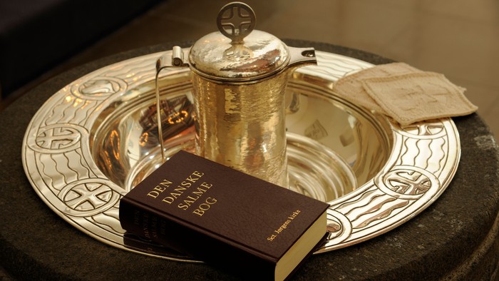 En sølvkande og en bibel på en sølvtæppe