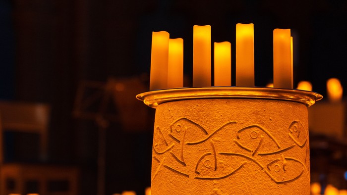 Taufbecken in der Apostel-Paulus-Kirche, umgeben von Lichtern