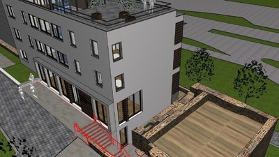 Luftaufnahme eines modernen Gebäudes mit einer Baustelle und angrenzender Grünfläche.