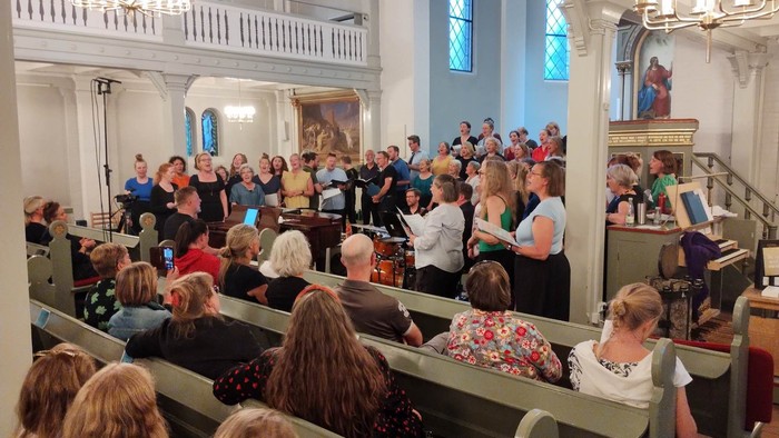 En kirke med en stor samling af mennesker, der deltager i en gudstjeneste.
