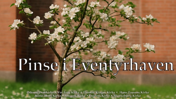 Blomstrende træ foran murvæg med teksten 'Pinse i Eventyrhaven'