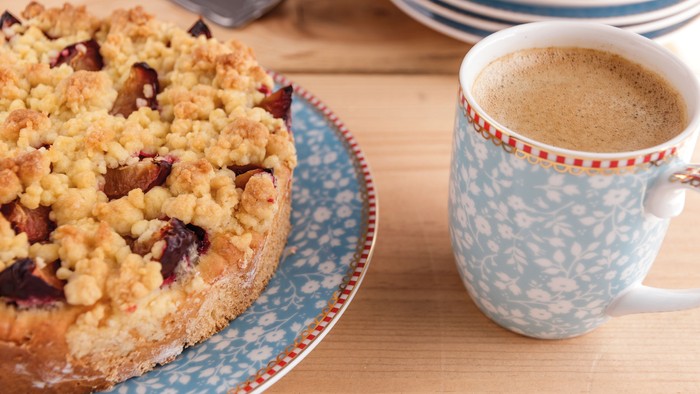 Ein Kuchen und eine Tasse Kaffee auf einem Holztisch
