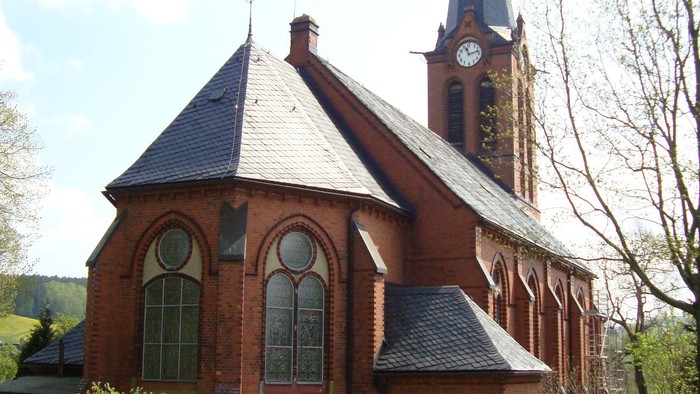 Kirchengrundstück mit Kirche, Uhrturm und Grabsteinen