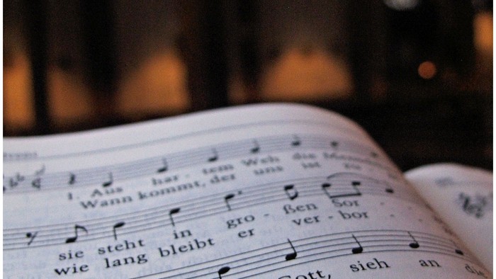 Noten auf einem offenen Buch in einem schwach beleuchteten Raum.