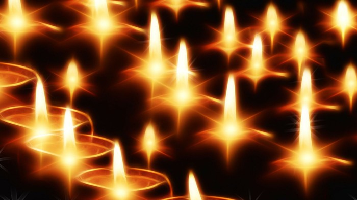 Viele brennende Kerzen in der Dunkelheit