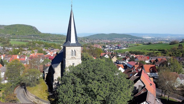 Kleinstadt mit Kirche, Häusern und umliegender Landschaft.