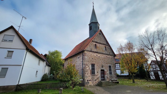 Kirchengelände mit Kirche, Wohnhäusern und Bäumen