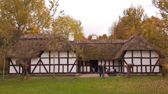 Hvid bondegård med bindingsværk og stråtag.