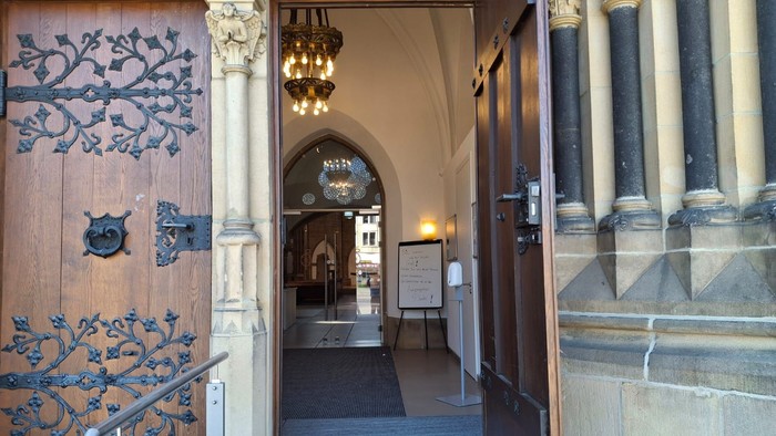 Der Eingang eines historischen Gebäudes mit verzierten Türen und Säulen.