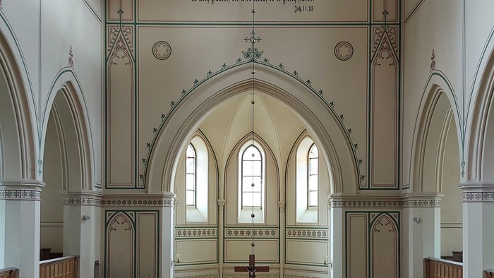 Großzügige Kirche mit hohen Bögen und Stufen zum Altar.