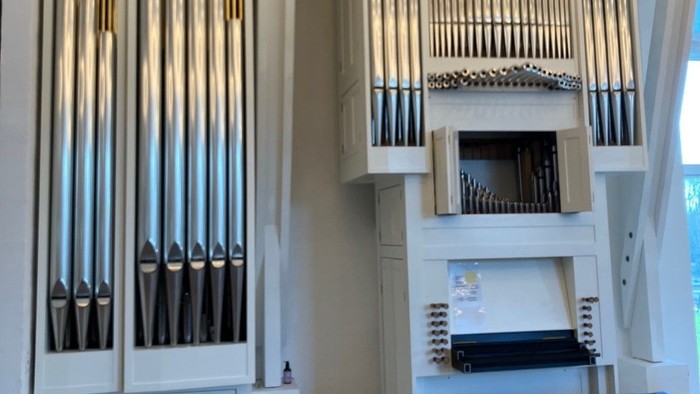 Stor hvid orgel i lys og rummelig rom