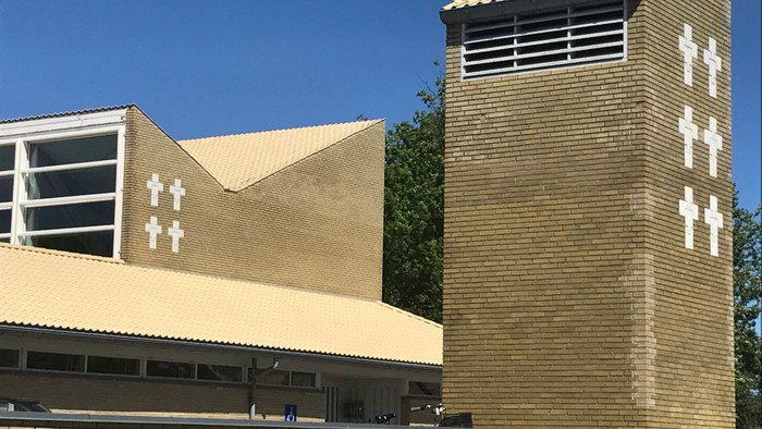 Bygningen har to tårne med kors og fladt tag