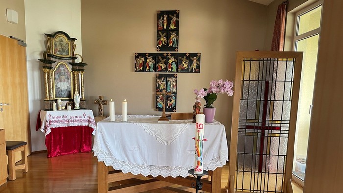 Eleganter Kapellenaltar, geschmückt mit Kerzen, Blumen, religiöser Kunst und einem ruhigen Holzaufbau.