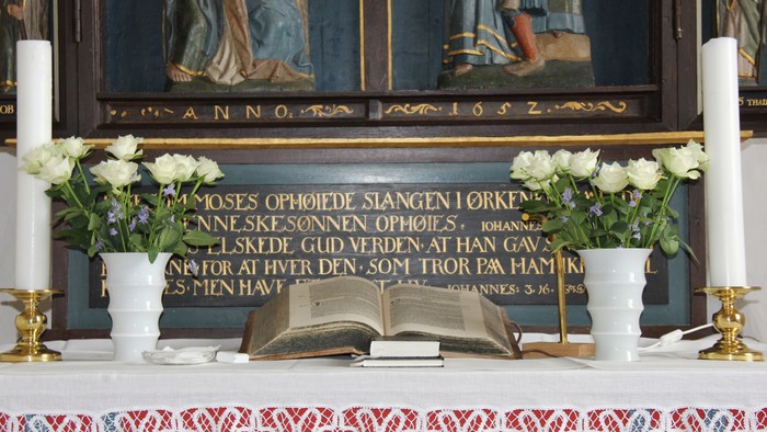 Kirkens alter med hvide roser i buketter