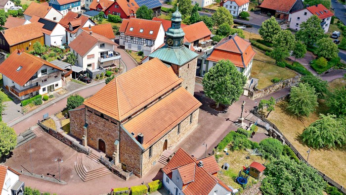 Ein Luftbild einer kleinen Stadt mit einem historischen Kirchgebäude im Mittelpunkt.